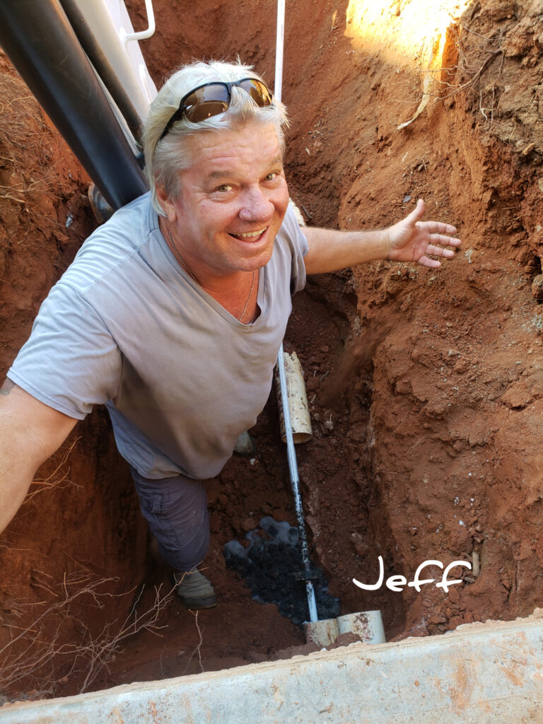 Rideout Plumbing technician digging a trench for sewer line access